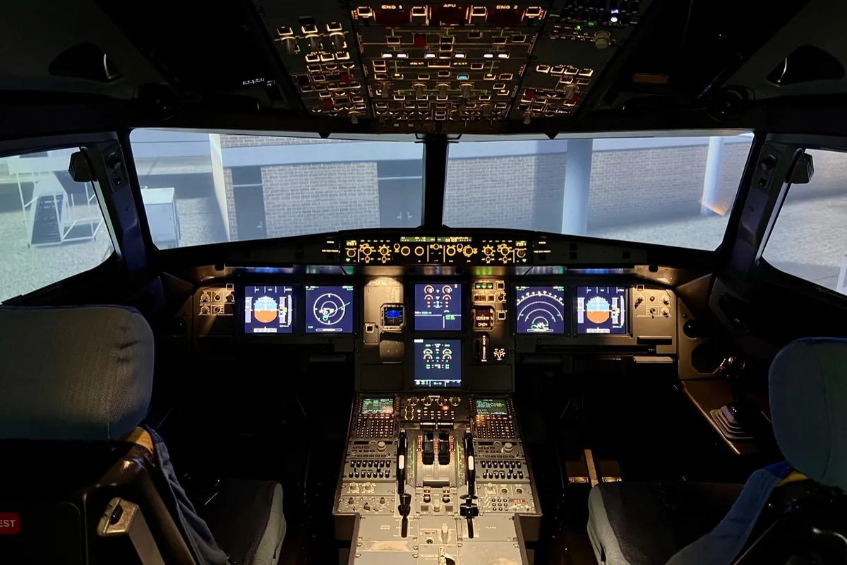 Airbus A-320 simulator flight deck with the visual system showing an airport ramp