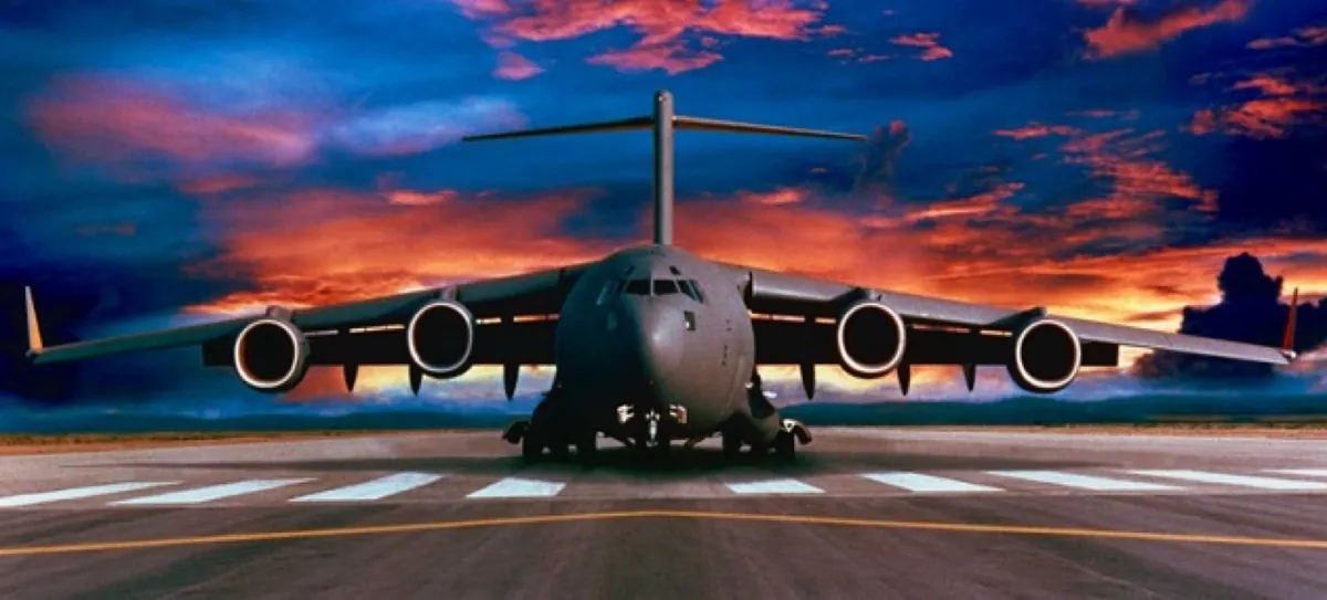 C-17 military jet transport on a runway at sunset