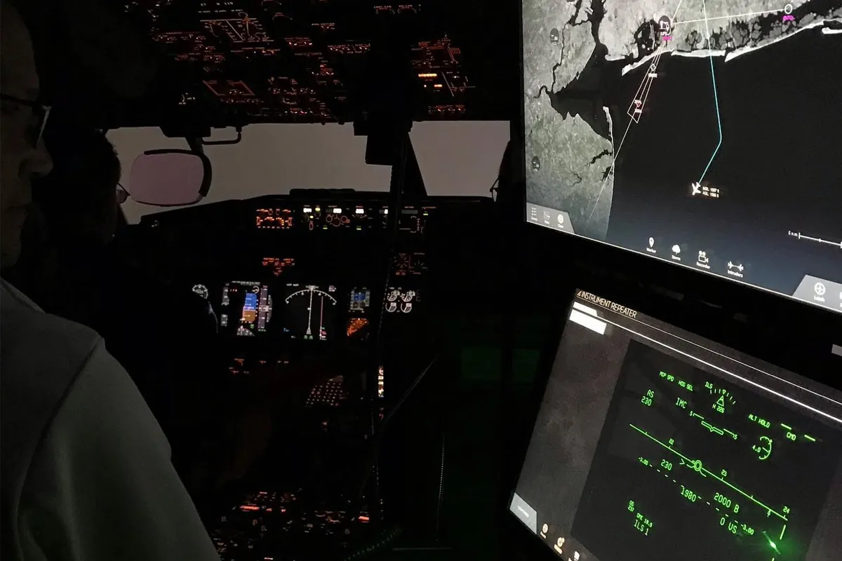 Simulator instructor station screens beside a full flight simulator flight deck at DFW, Dallas, Building 1