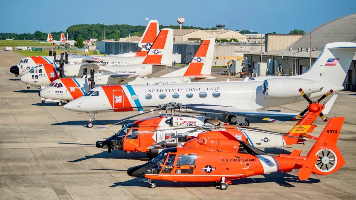 U.S. Coast Guard helicopters and fixed-wing aircraft lined up on a ramp