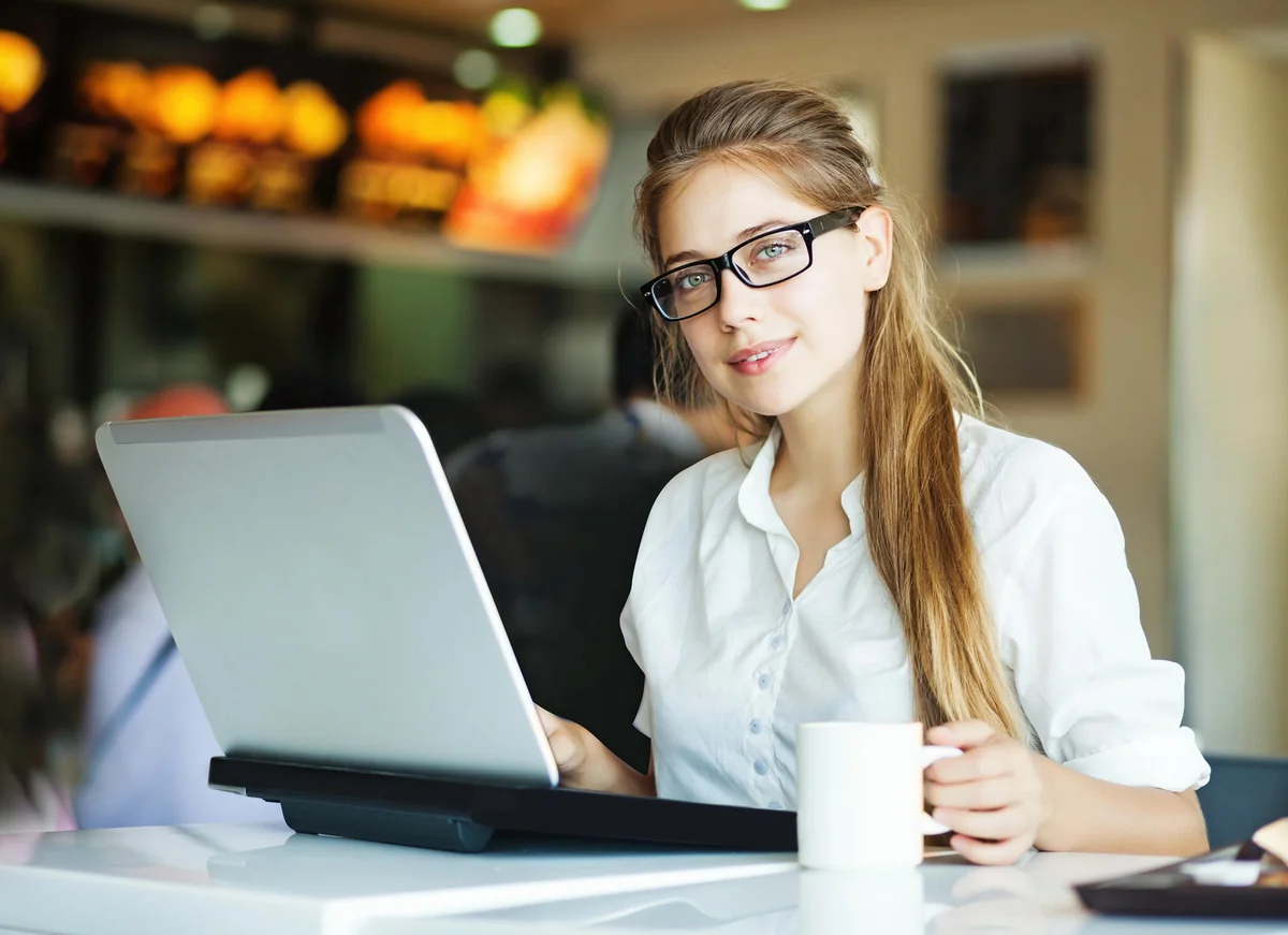 Woman studying at a laptop with a cup of coffee, representing live ATP CTP ground school in the GCAS virtual classroom