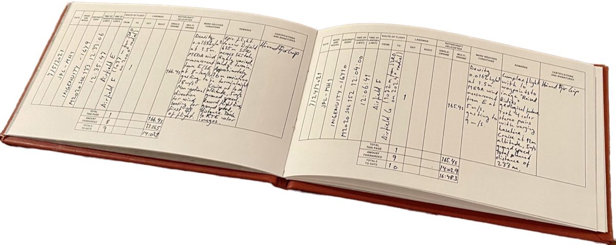 Open pilot logbook with handwritten flight entries